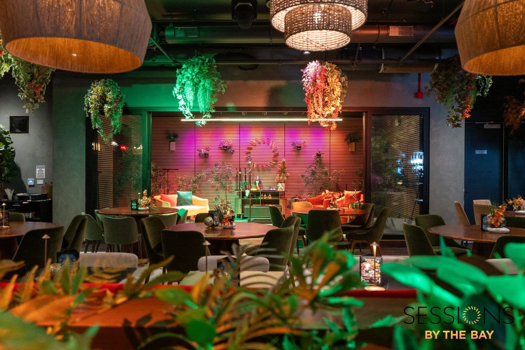 The stage-area lounge with velvet chairs and hanging greenery, set before a show