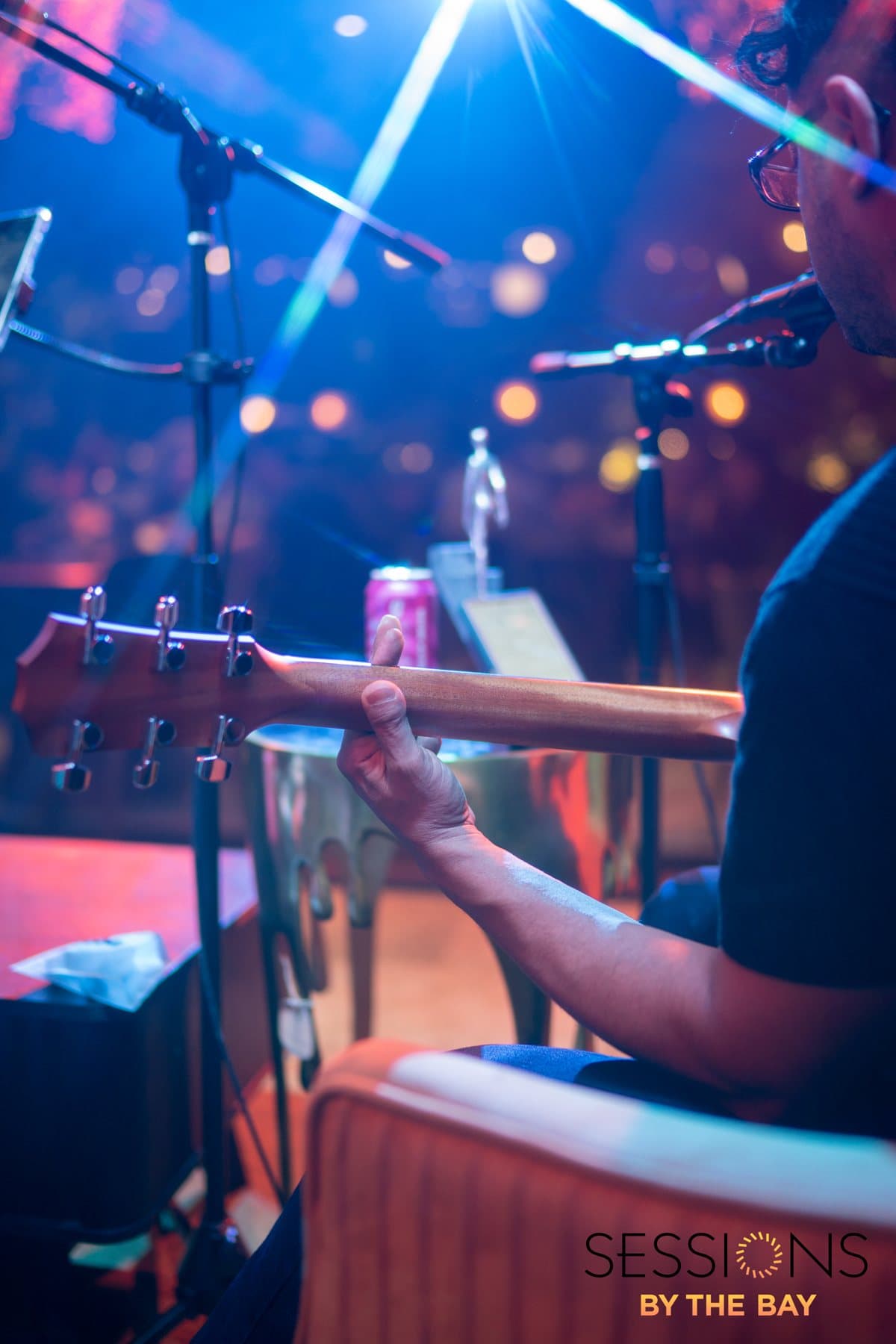 A guitarist tuning up on stage under the lights